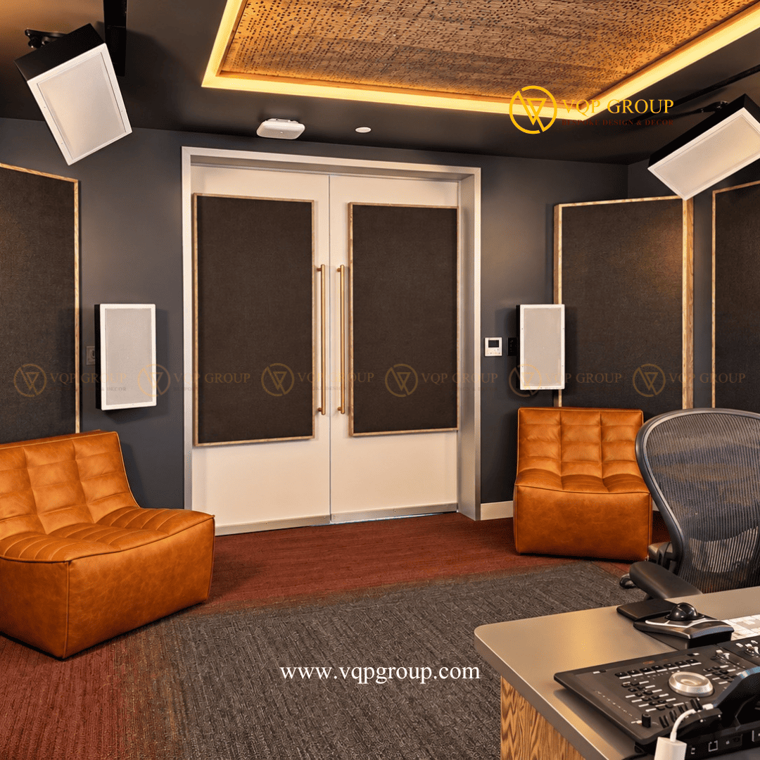  Khu vực cửa ra vào và nội thất phòng thu âm AMBER STUDIO Mô tả ảnh: Hệ cửa hai cánh màu trắng có mảng hoàn thiện bọc vải, hai ghế ngồi màu nâu da và các tấm tiêu âm trên tường xung quanh.