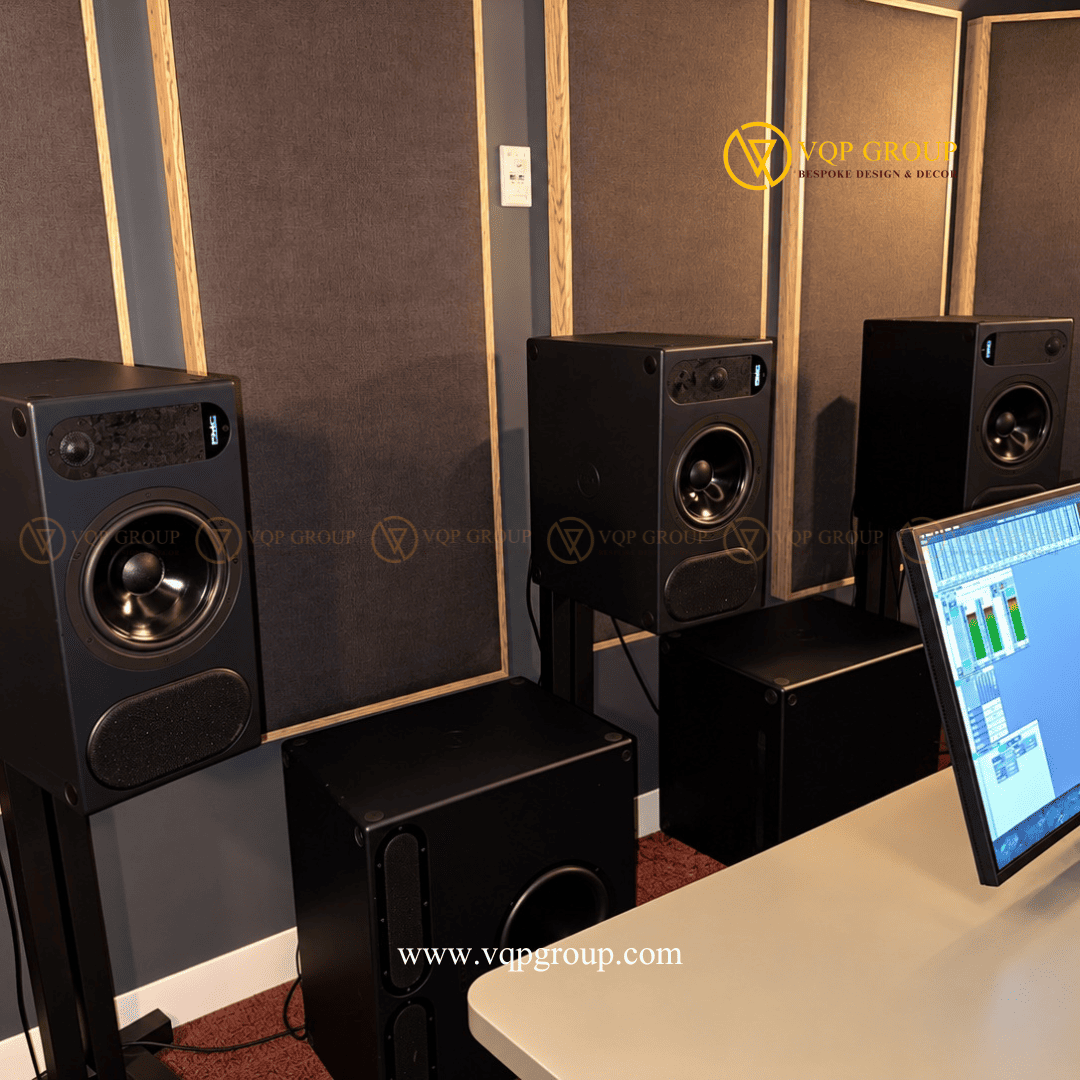 Loa kiểm âm kết hợp hệ tấm tiêu âm tường trong phòng thu AMBER STUDIO Mô tả ảnh: Hình ảnh cận cảnh các loa kiểm âm đặt trên chân đỡ, thiết bị loa tần số thấp phía dưới và hệ tấm tiêu âm bọc vải khung gỗ phía sau.