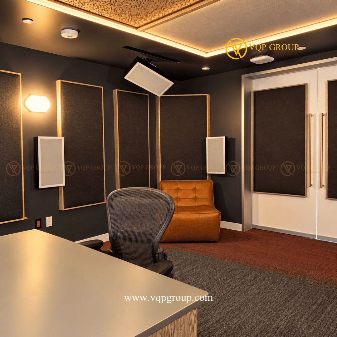 Nội thất phòng thu AMBER STUDIO với hệ tấm tiêu âm tường và ánh sáng trần Mô tả ảnh: Góc nhìn từ bên hông cho thấy hệ tấm tiêu âm bọc vải khung gỗ, ghế ngồi bọc da nâu, cửa hai cánh và trần đục lỗ kết hợp đèn LED.
