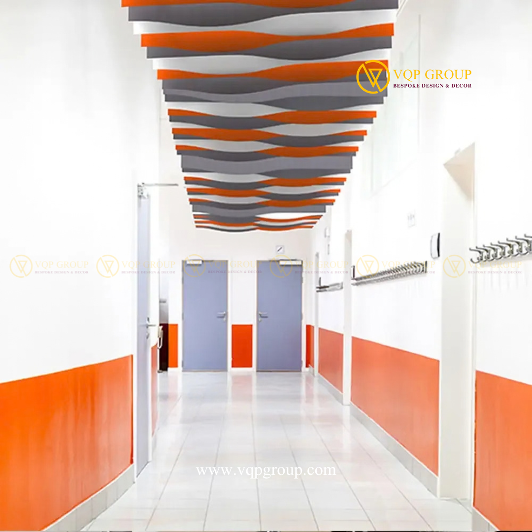 Hệ trần PET Baffle Clouds dạng lam gợn sóng phối màu cam xám trắng tại hành lang